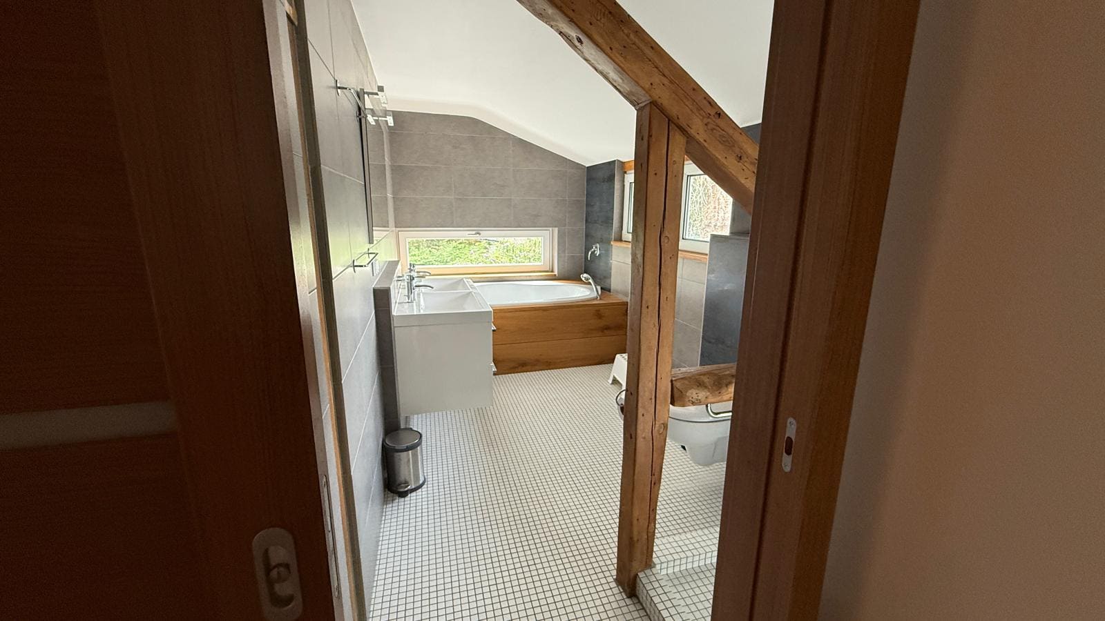 Badezimmer mit Waschtisch, Badewanne und Holzbalken